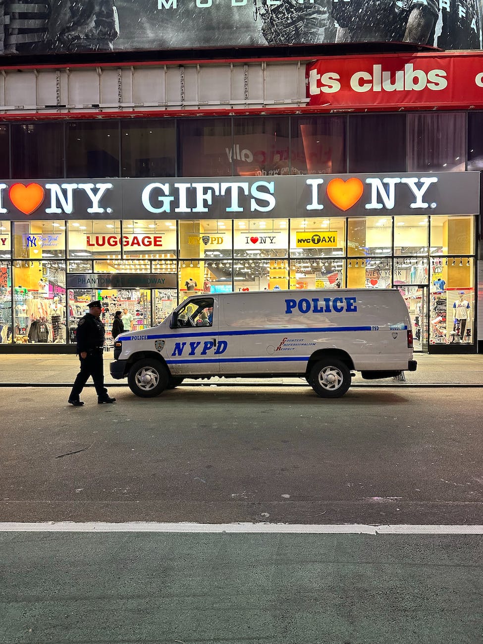 a police white van parked near the building with glass windows